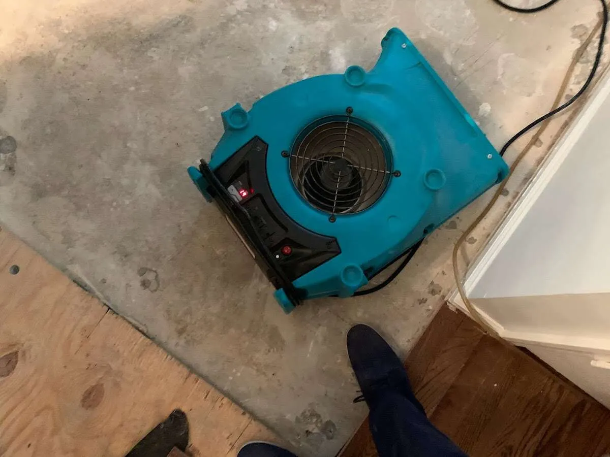 Air mover drying subfloor during Commercial Water Damage Restoration in Texas